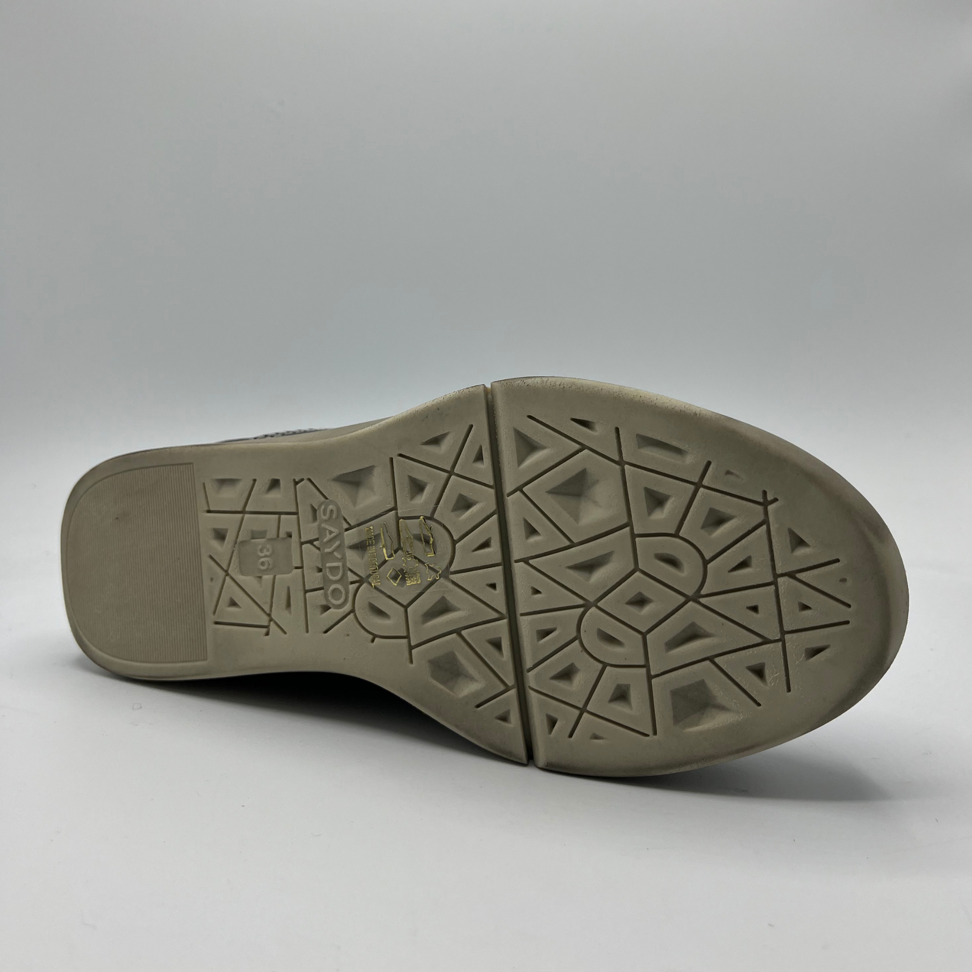 Close-up of a shoe sole with geometric pattern on a gray background