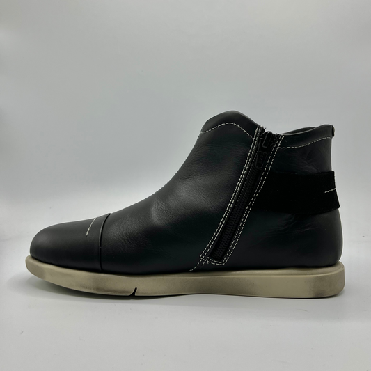 Black leather ankle boot on a light gray background