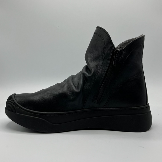 Black leather boot on a gray background