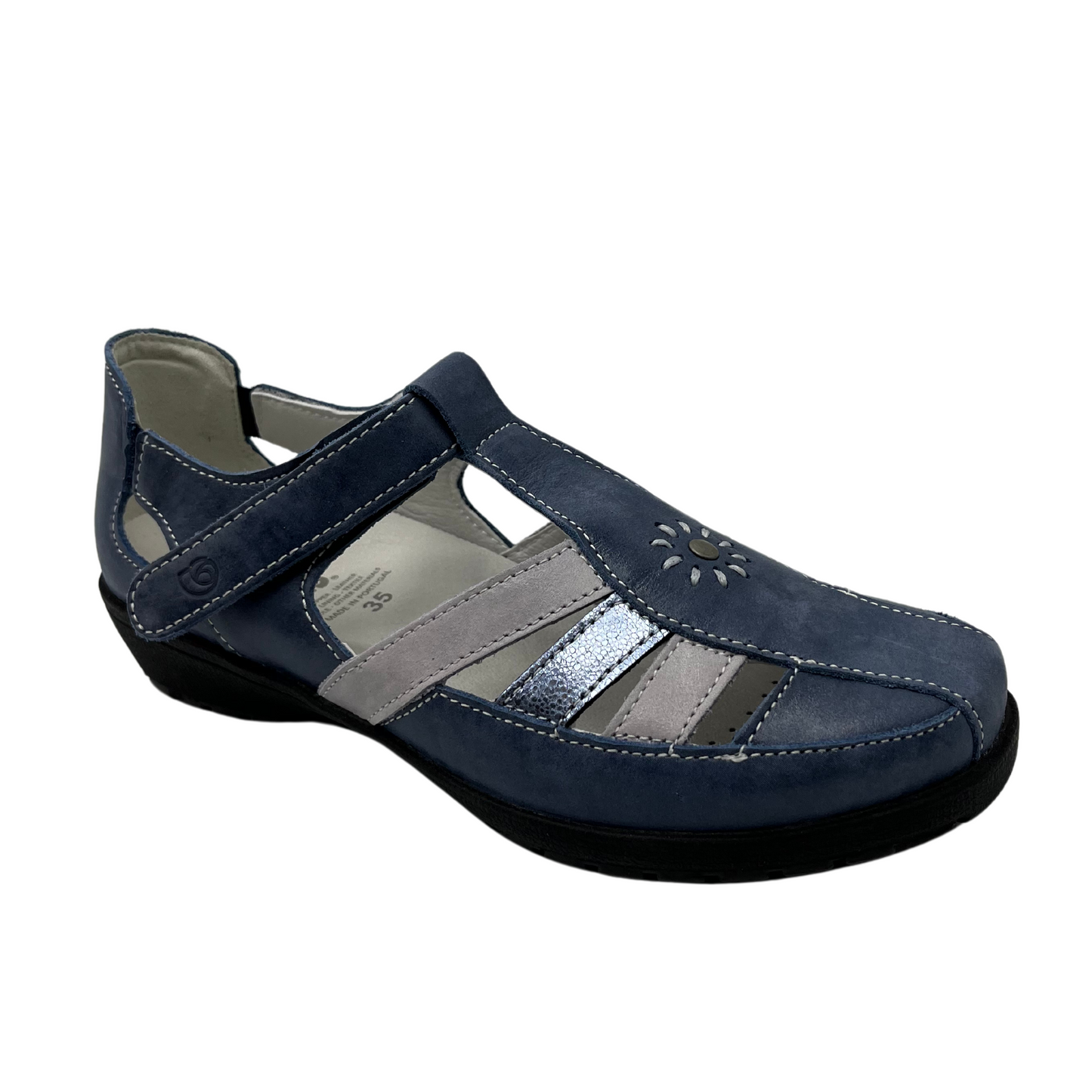 45 degree angled view of blue leather shoe with white and blue metallic straps and velcro on ankle strap