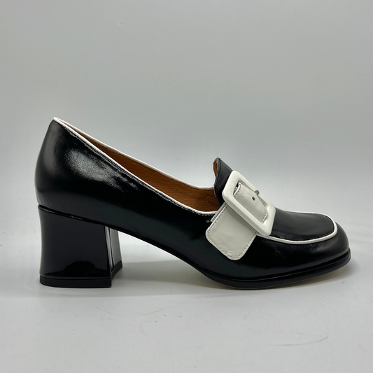 Black shoe with a white buckle on a gray background
