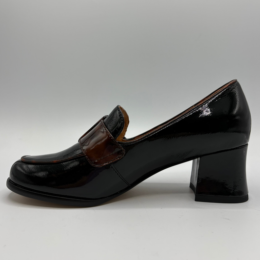 Left facing view of a patent leather high heeled shoe with a decorative tortoise shell patterned buckle