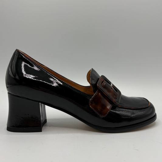 Right facing view of a patent leather high heeled shoe with a decorative tortoise shell patterned buckle