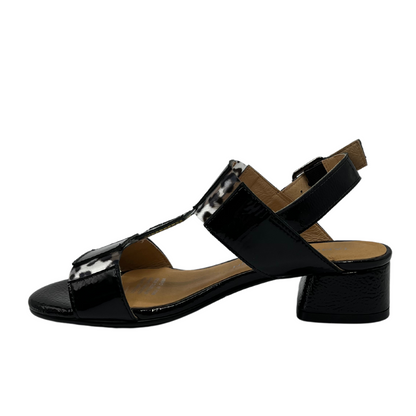 Left facing view of black patent sandal with block heel and buckle strap