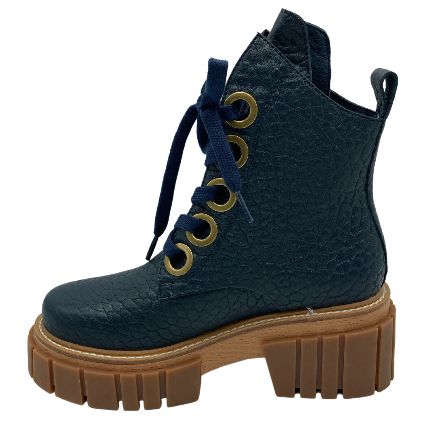 Left facing view of navy textured leather boot with gold eyelets for navy laces and chunky brown rubber outsole