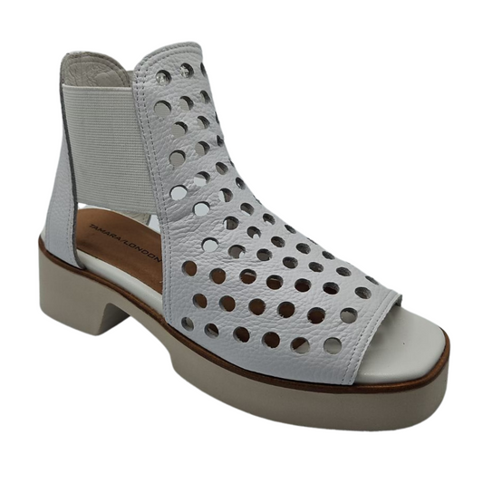 45 degree angled view of white perforated leather sandals with elastic sides and platform sole