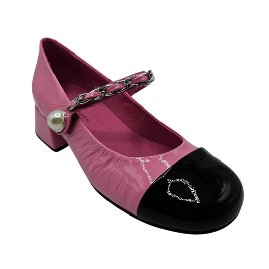 45 degree angled view of pink and black patent leather mary jane with pearl and chain details on the strap and short block heel