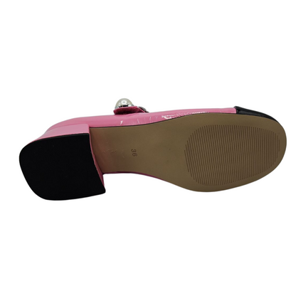 Bottom view of pink and black patent leather mary jane with pearl and chain details on the strap and short block heel