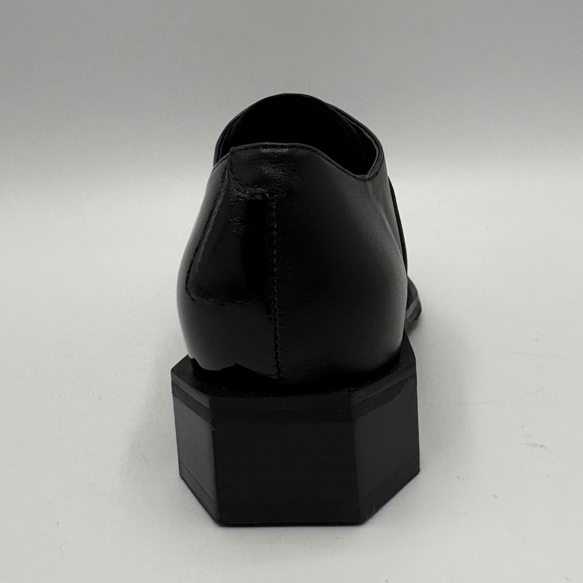 Back view of a black shoe with a geometric heel