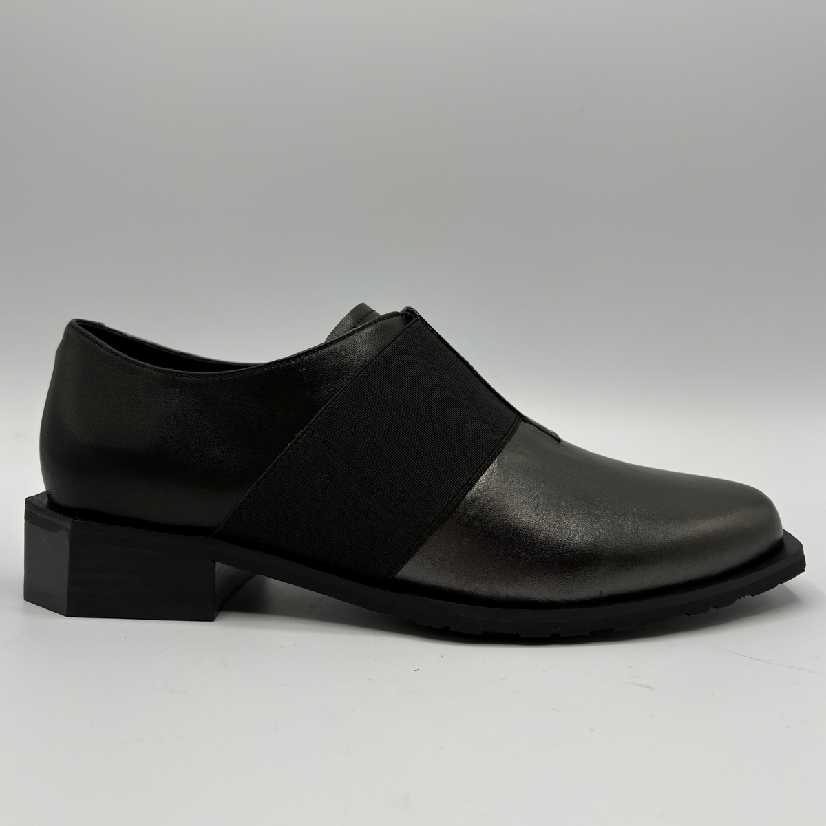 Right facing view of a black shoe with a geometric heel