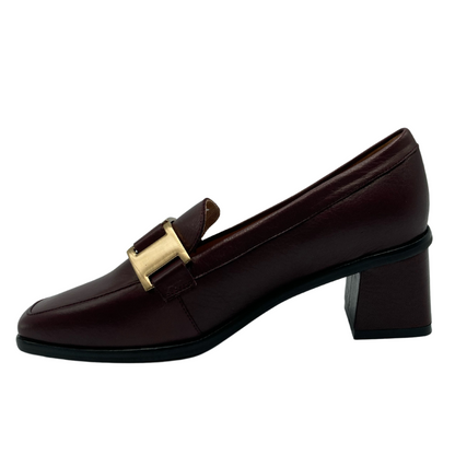 Left facing view of burgundy loafer with block, leather covered heel with gold, buckle detail on upper. 