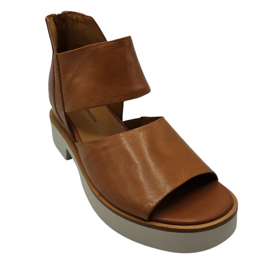 45 degree angled view of brown leather sandals with back zipper closure, white platform sole and open toe