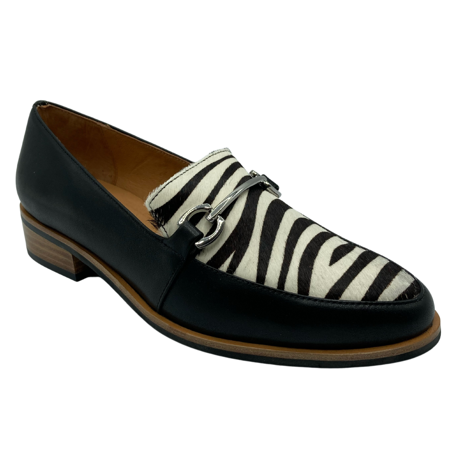 45 degree angled view of black and zebra print loafer with silver buckle detail on upper