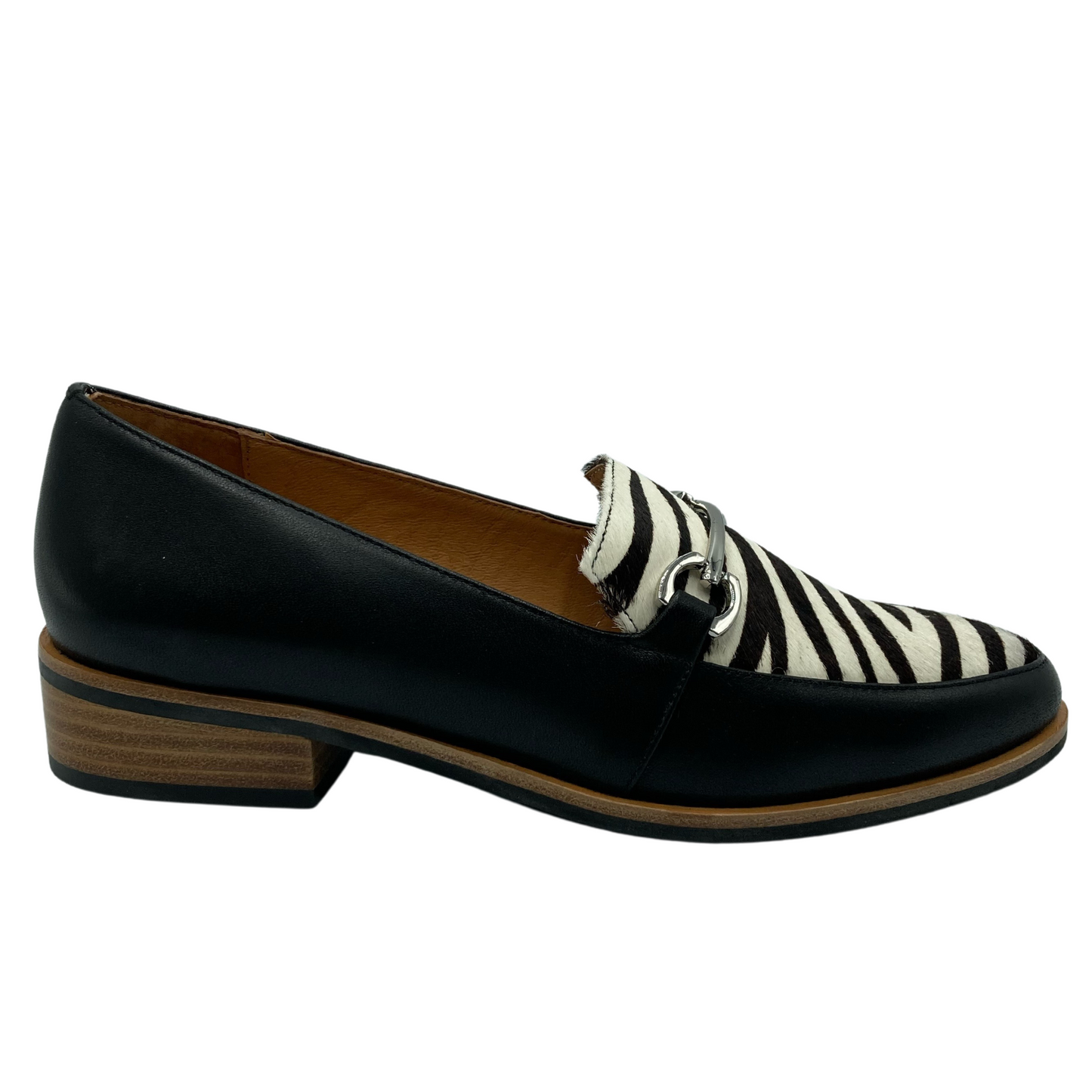 Right facing view of black and zebra print loafer with low heel and silver buckle detail on upper