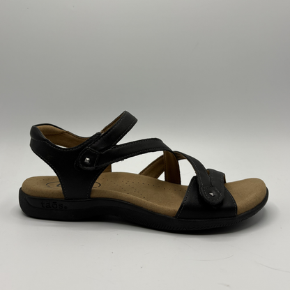 Black sandal with brown sole on a gray background