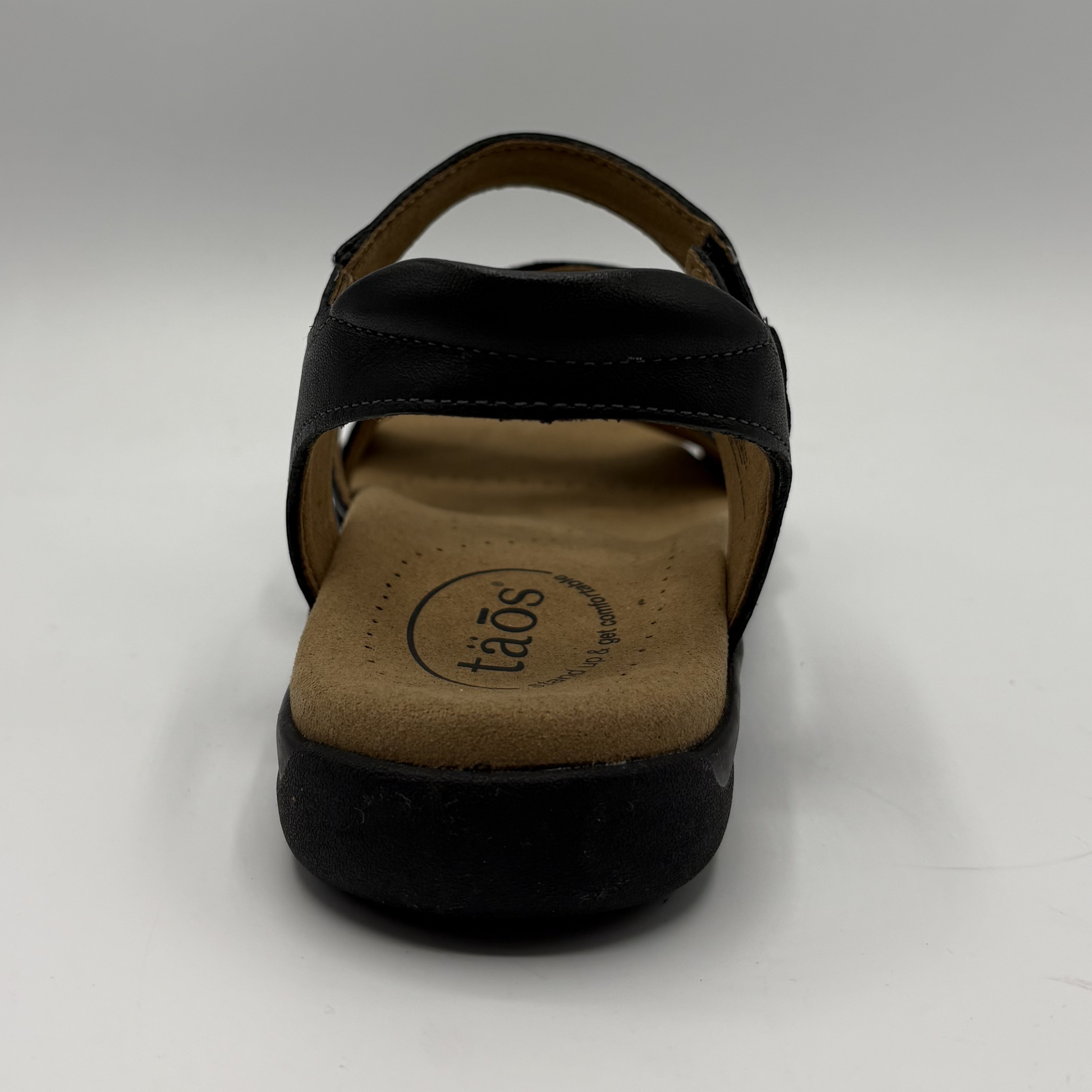 Black sandal with a visible brand logo on a white background