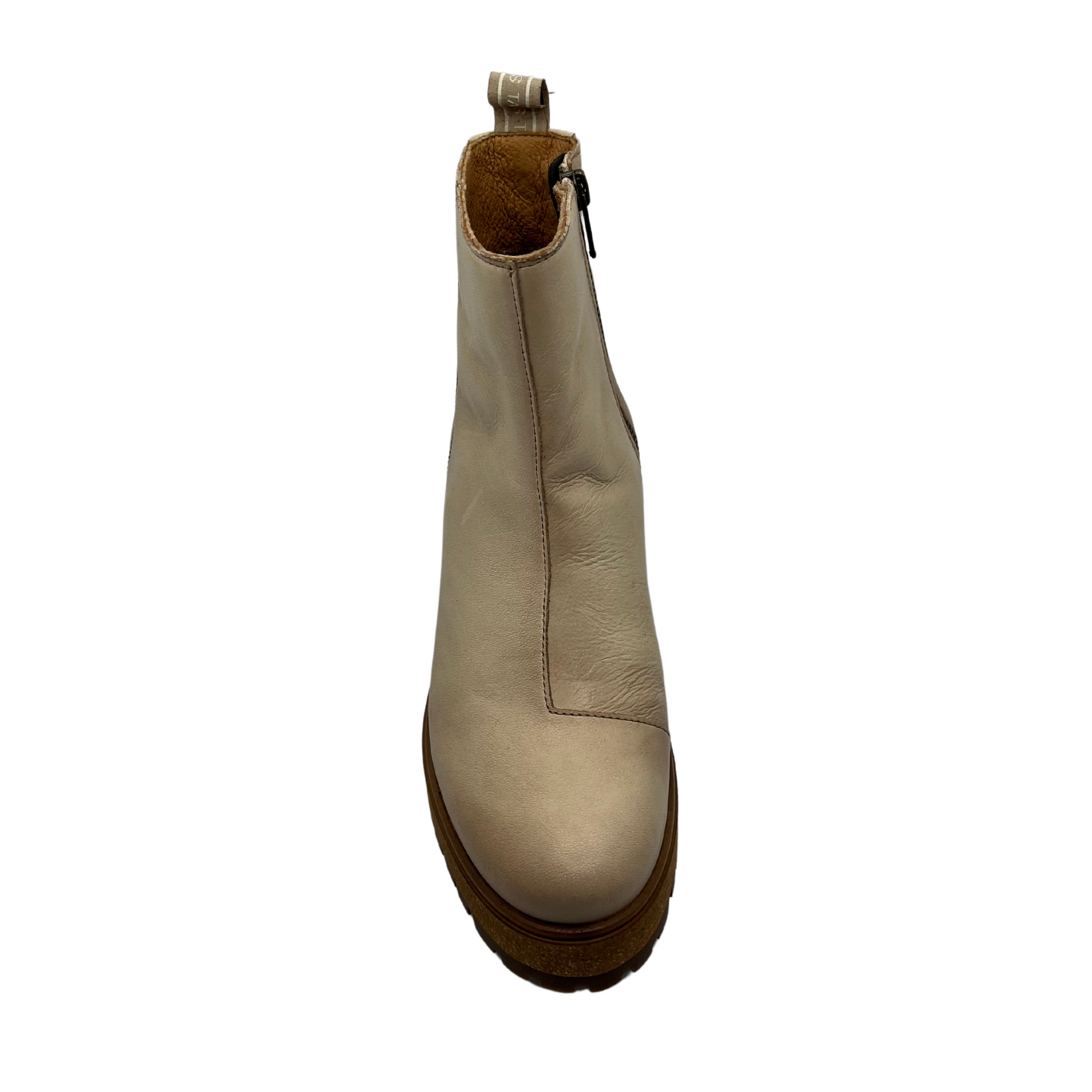 Top view of ivory leather short boot with rubber and cork outsole with inner zipper closure and pull on tab