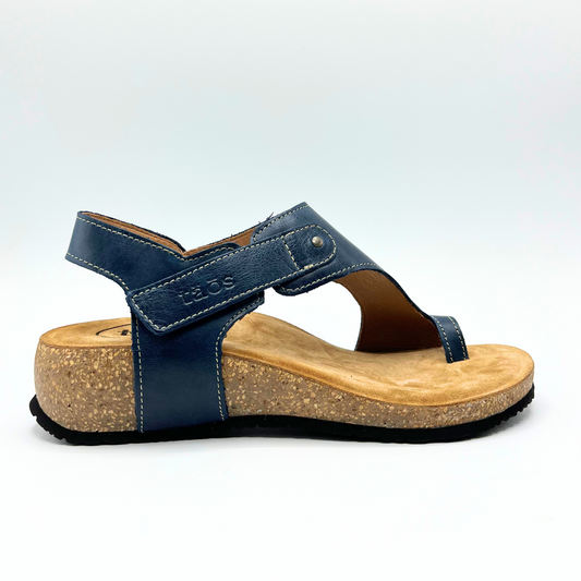 Right facing view of a petrol blue leather sandal with a suede wrapped footbed and 1 1/4 inch cork wedge outsole.