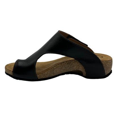 Left facing view of black leather sandal with brown leather lined footbed. Hook and loop closure on strap and toe strap