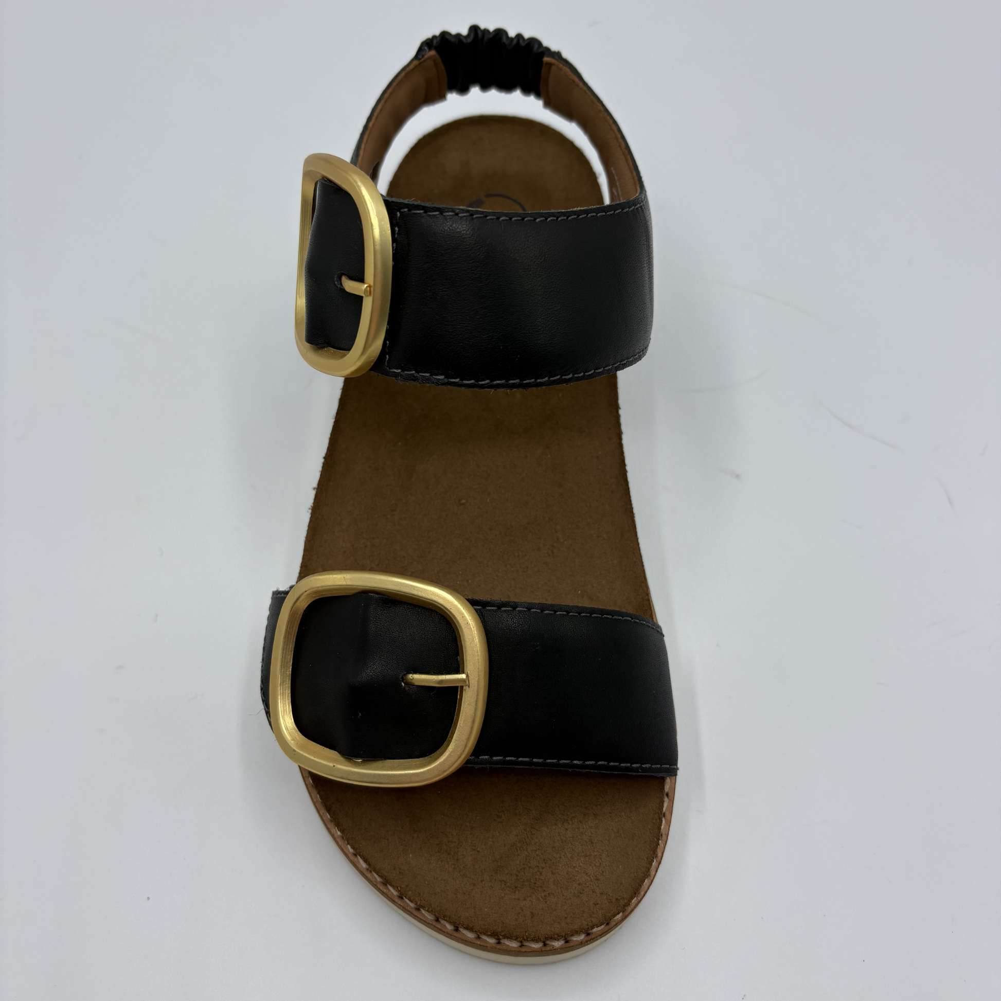Top view of a black strapped sandal with gold buckles and a cork footbed