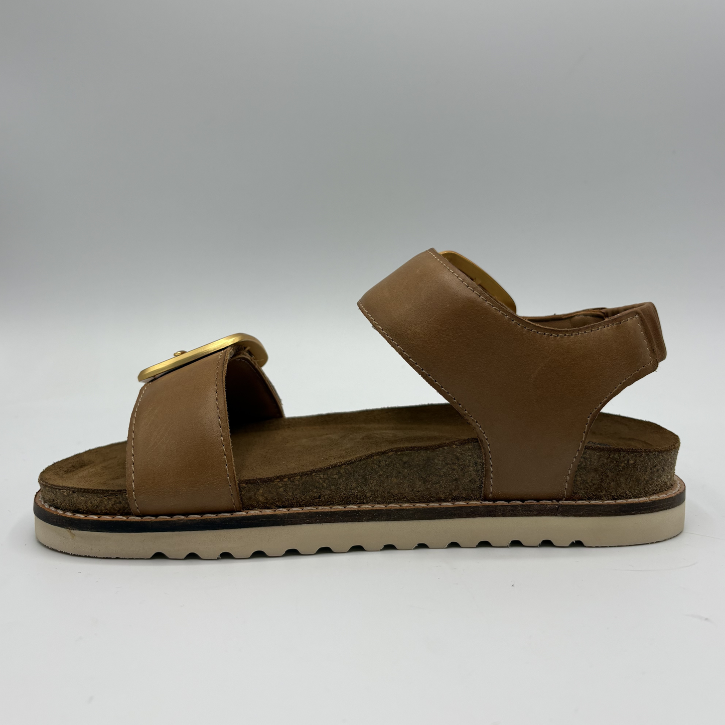 Brown sandal with a gold buckle on a white background