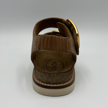 Brown sandal with a visible brand logo on a white background