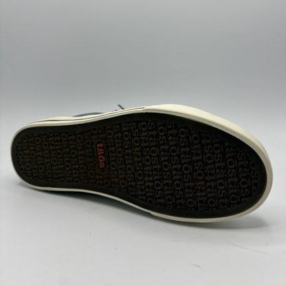 Close-up of a shoe sole with brand logo on a gray background