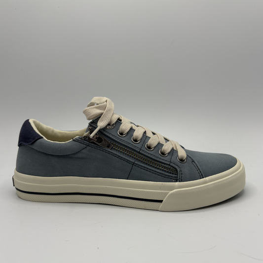 Blue sneaker with white laces on a gray background