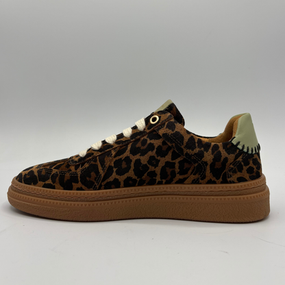 A low-top sneaker featuring a brown and black leopard print upper, white laces, and a thick brown gum sole, shown from a side profile view against a neutral gray background.