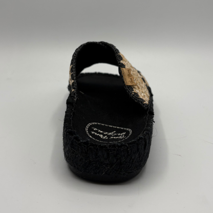 Black woven sandal with cork strap on a white background