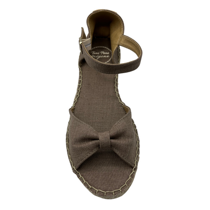 Top view of taupe low wedge sandal with bow strap on toe and buckle ankle strap