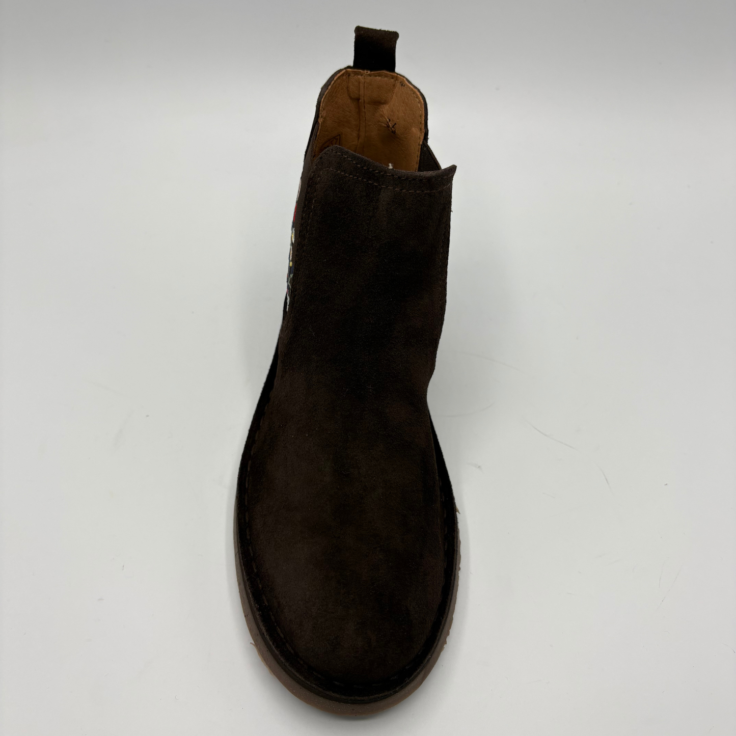 A dark brown suede Chelsea boot shown from a top-down angle on a light gray background.