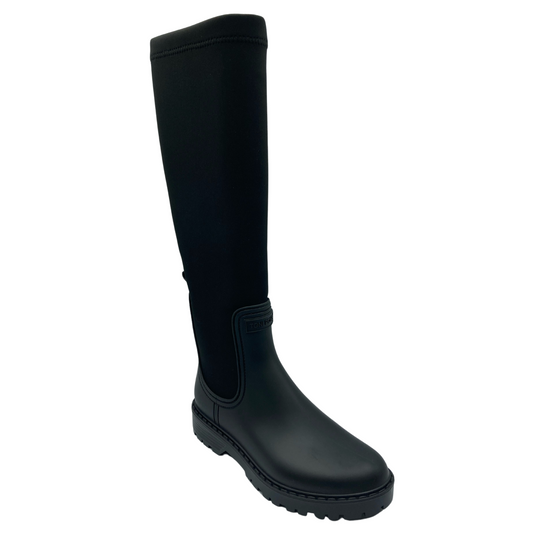 45 degree angled view of tall black boot with rubber upper and lycra calf