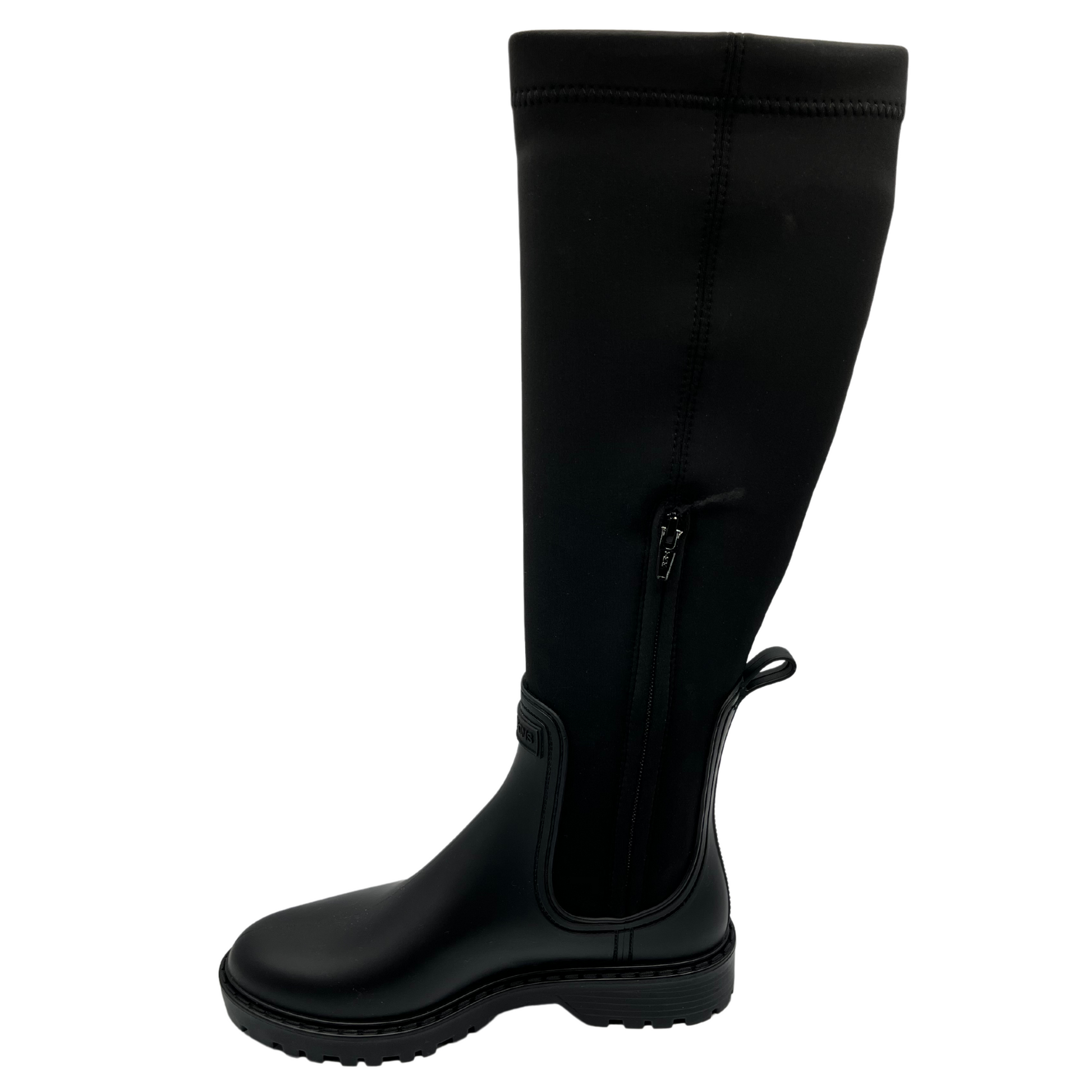 Left facing view of black rubber and lycra tall boot with rounded toe and black rubber outsole. Side zipper closure and pull on tab.