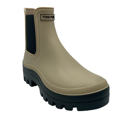 45 degree angled view of beige chelsea boot with black rubber sole and black elastic sides