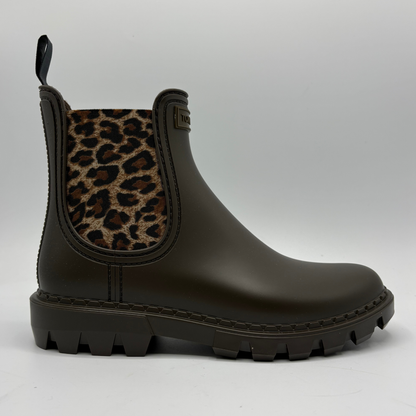 A dark brown Chelsea-style rain boot with a leopard-print elastic side panel and a chunky lug sole, shown in profile against a light gray background.