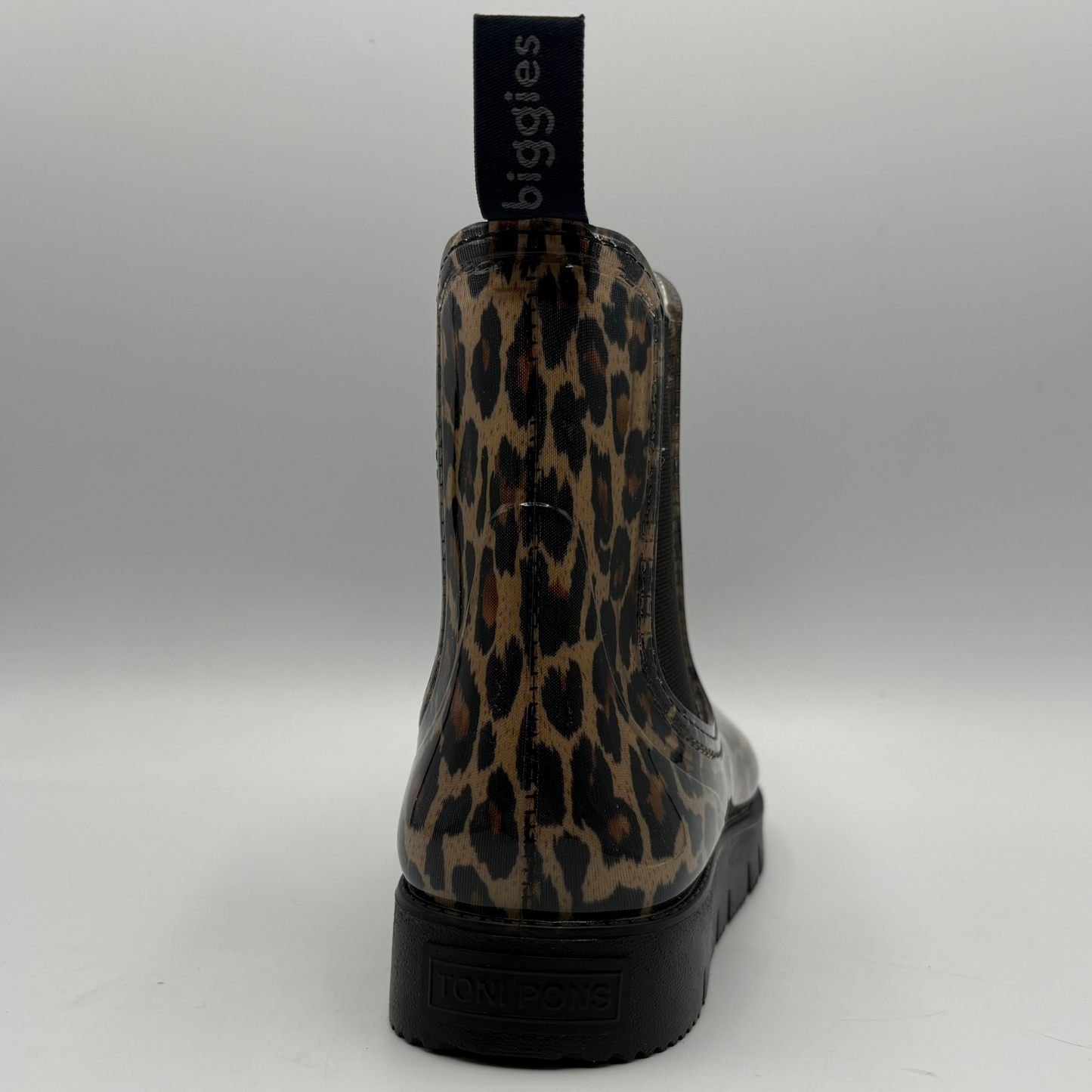 A single rain boot shown from the back, featuring a glossy leopard print pattern in brown, beige, and black, with a black pull tab