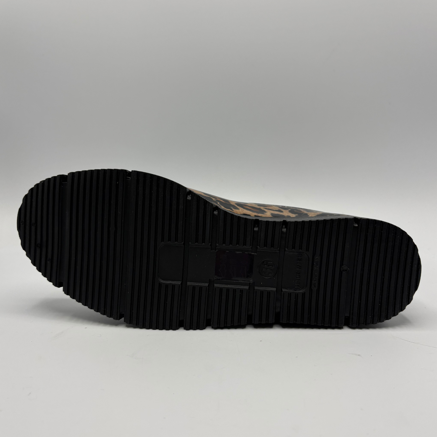 The black ribbed sole of a boot with a brown and black patterned upper, shown from a top-down view on a light gray background.
