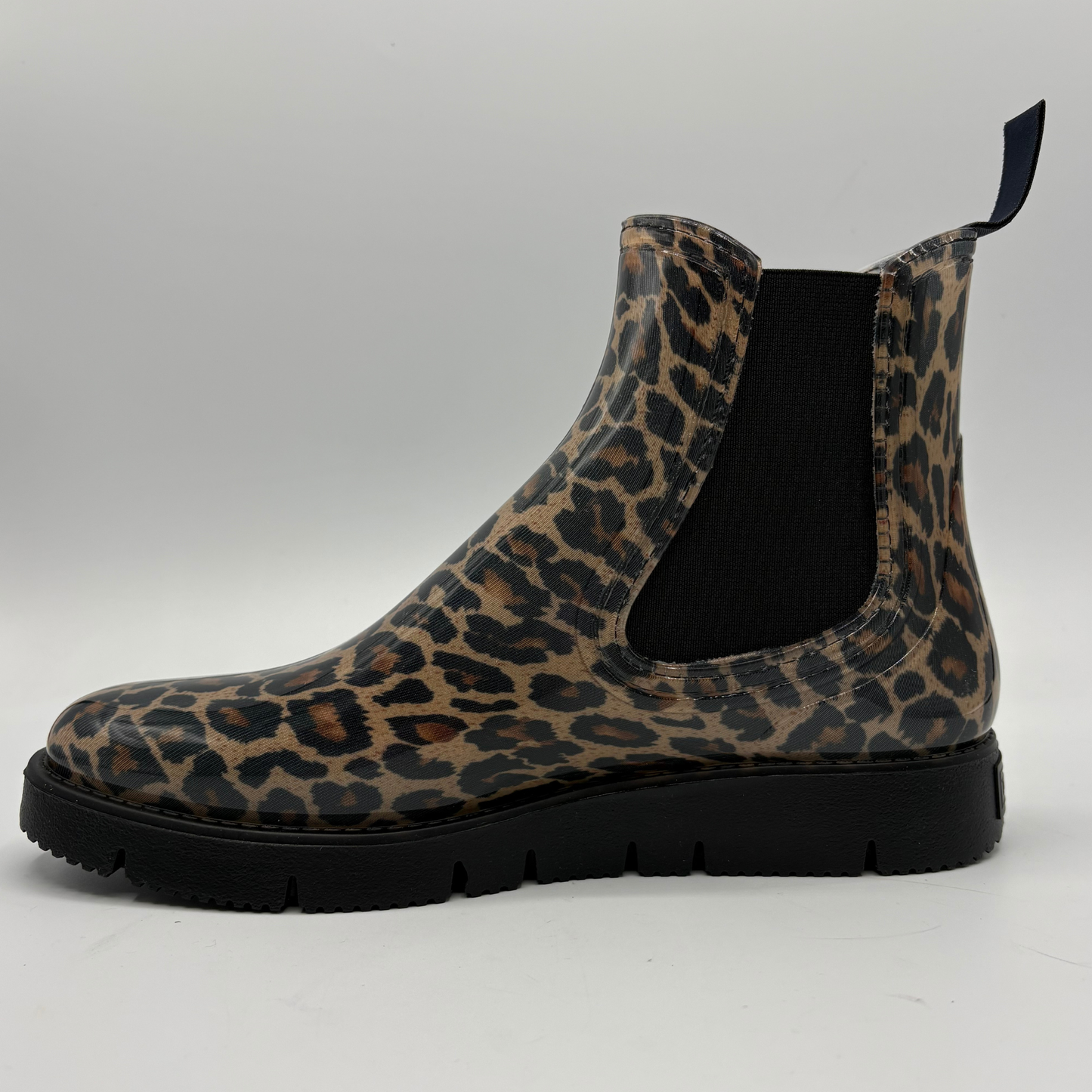 A single Chelsea-style ankle boot with a brown and black leopard print upper and a black elastic side gore, shown in profile against a light gray background.