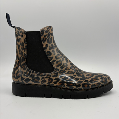 A single Chelsea-style rain boot with a leopard print pattern on a glossy finish, featuring black elastic side panels and a thick black lug sole, shown against a neutral gray background.