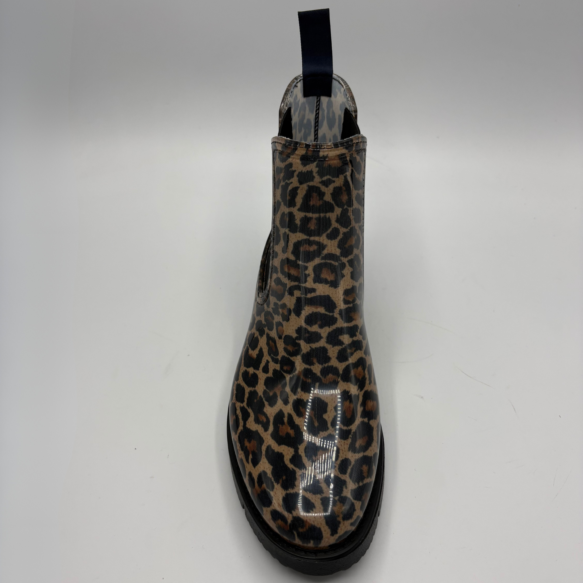 A single Chelsea boot with a glossy leopard print pattern in brown, black, and beige, featuring a black elastic side gore and a black pull tab at the top, photographed from a front-facing angle on a light gray background.