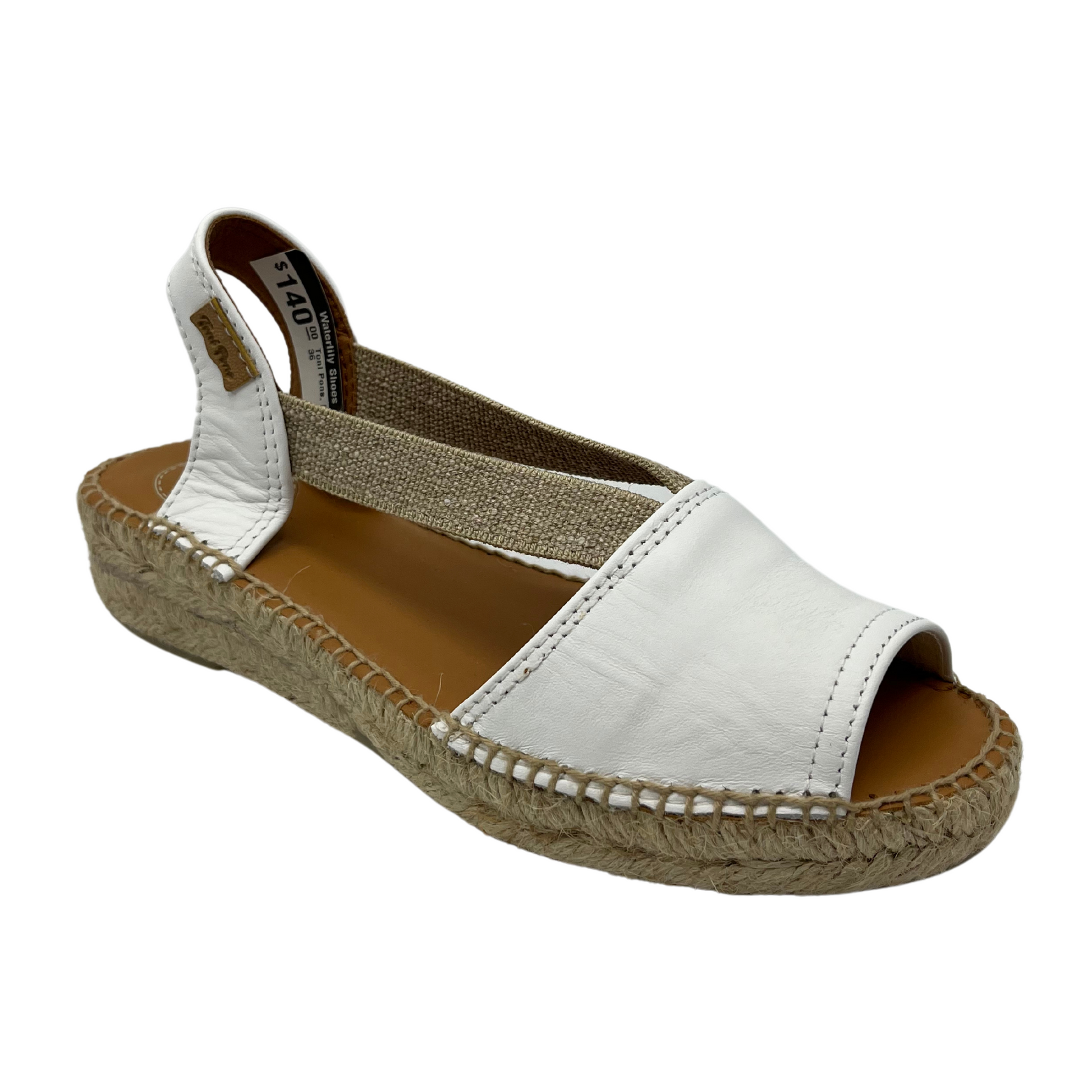 45 degree angled view of white leather sandals with double elastic straps and rounded toe