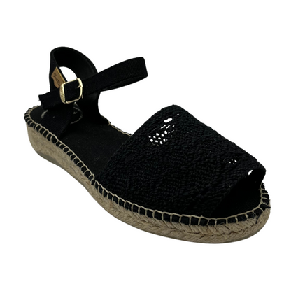 45 degree angled view of black macrame sandal with buckle strap and flat sole