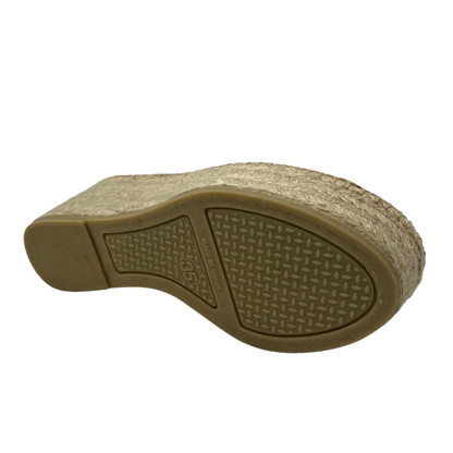 Bottom view of white leather espadrille with wedge heel and rubber outsole