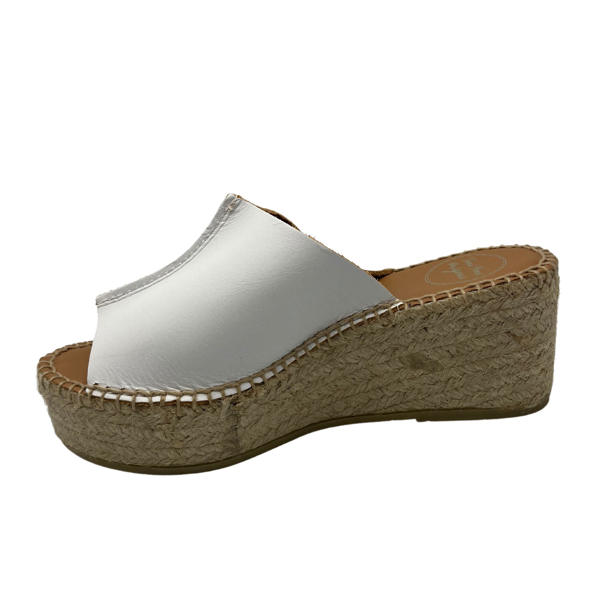 Left facing view of white leather espadrille sandal with wedge heel and handstitching around sole
