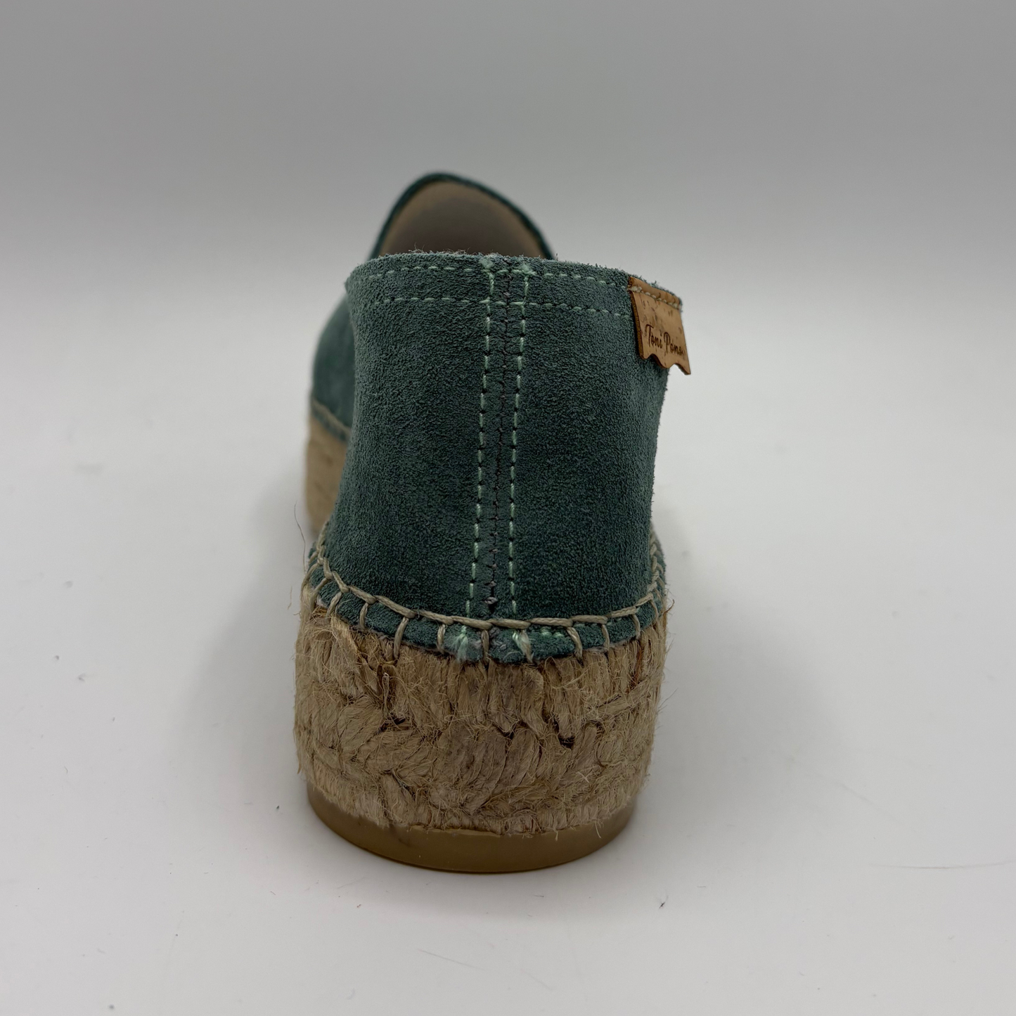 Green shoe with cork sole on a white background