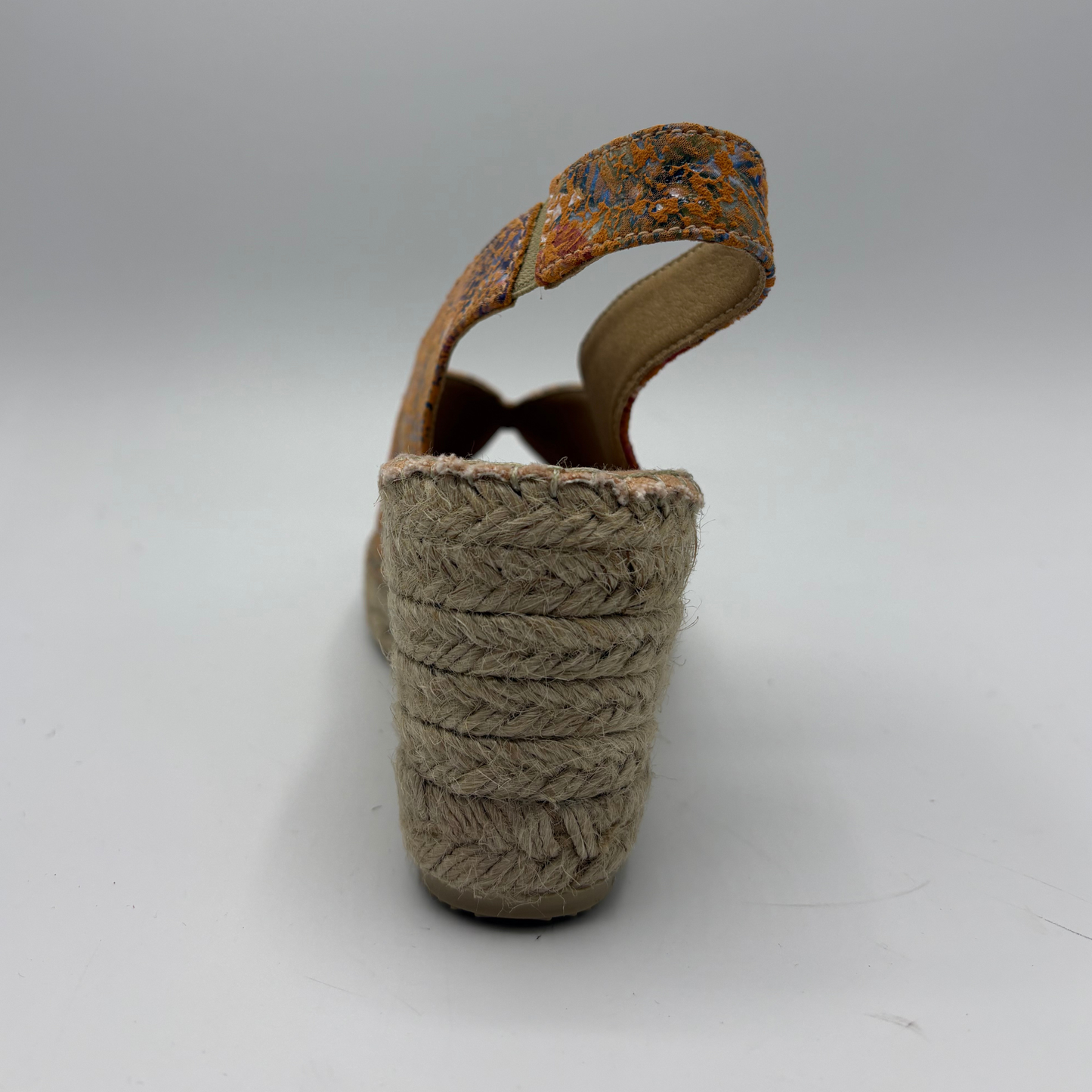 Brown woven sandal with a textured strap on a white background