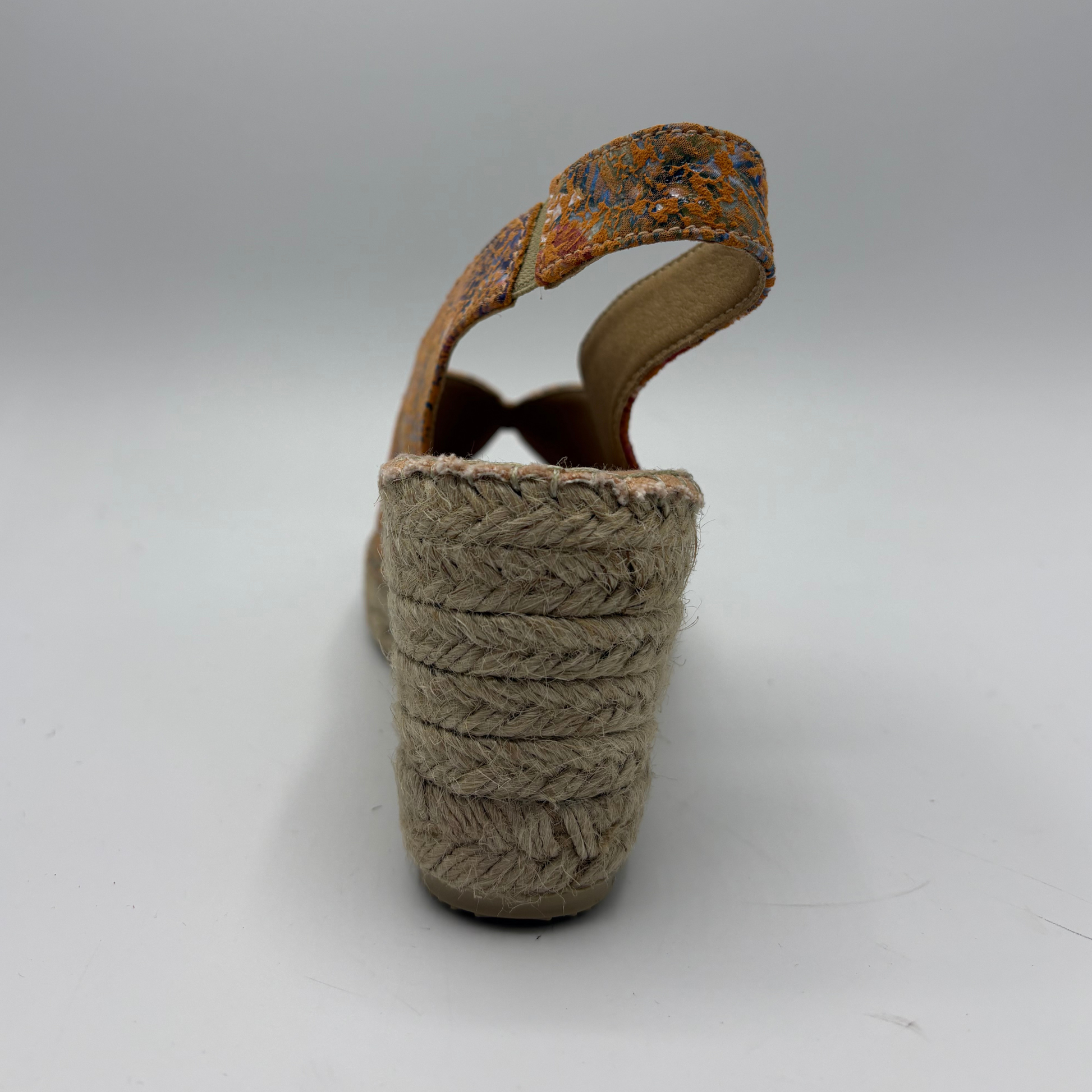 Brown woven sandal with a textured strap on a white background