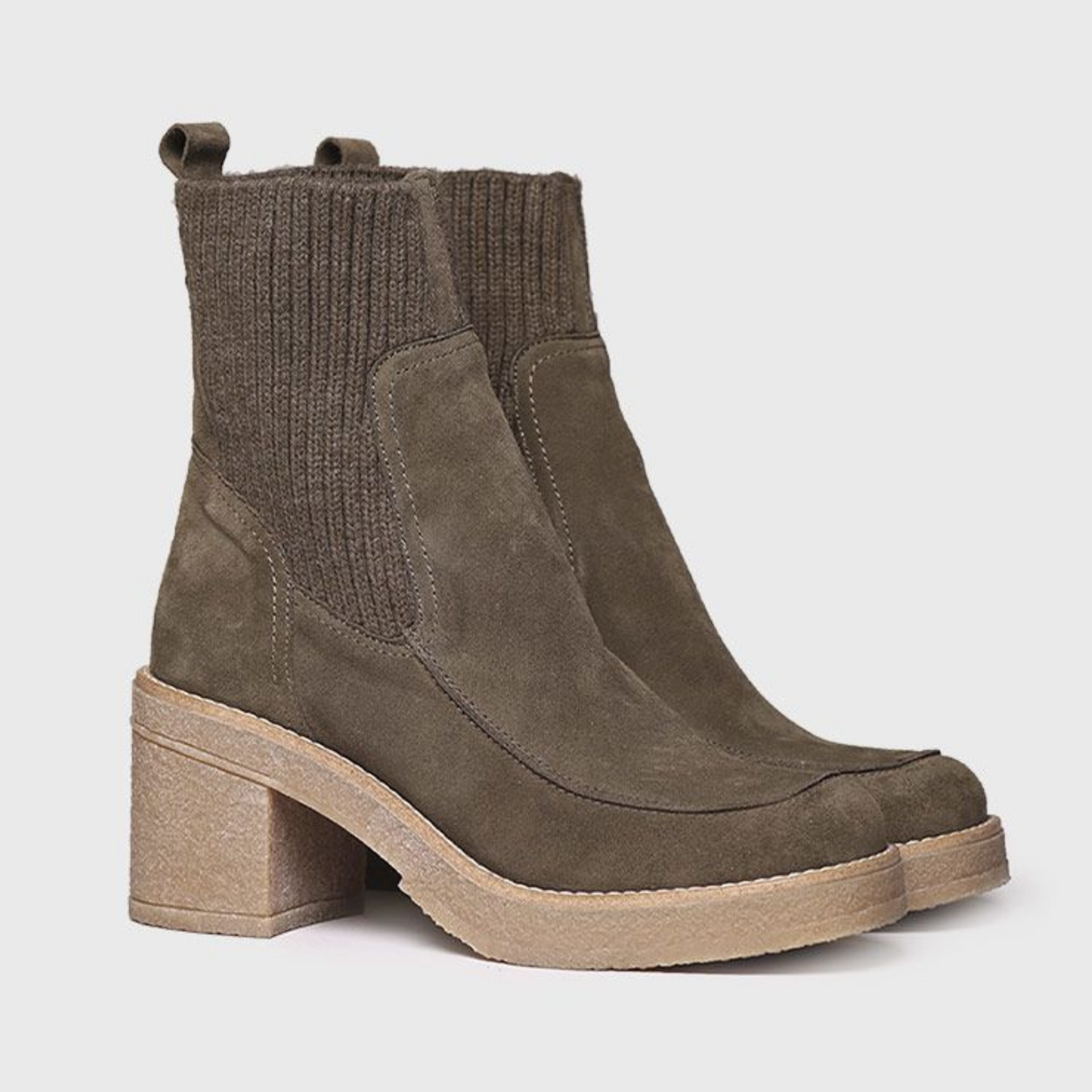 Angled view of of a pair of army green ankle boots with stretchy sock-like shaft