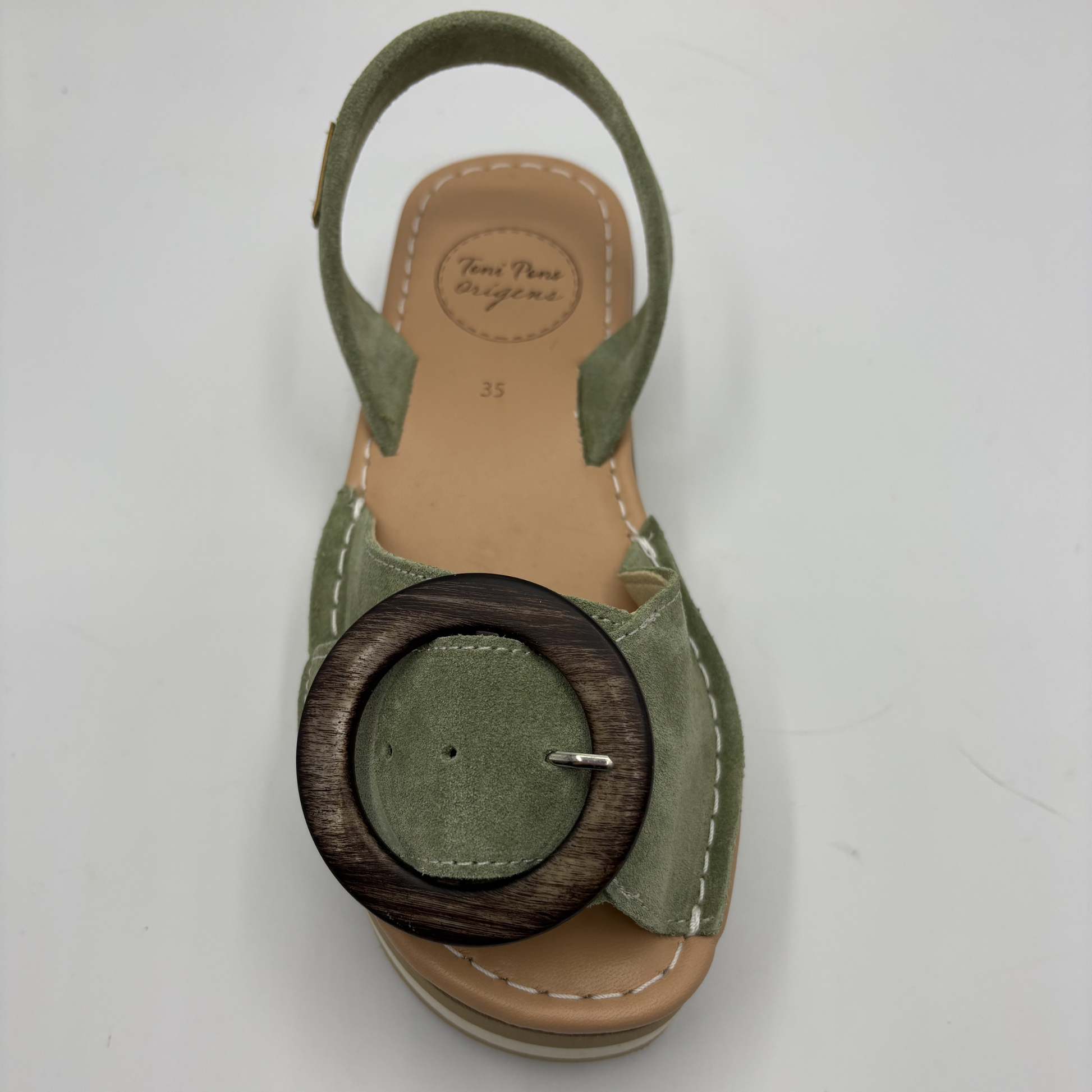Green sandal with wooden buckle on a white background